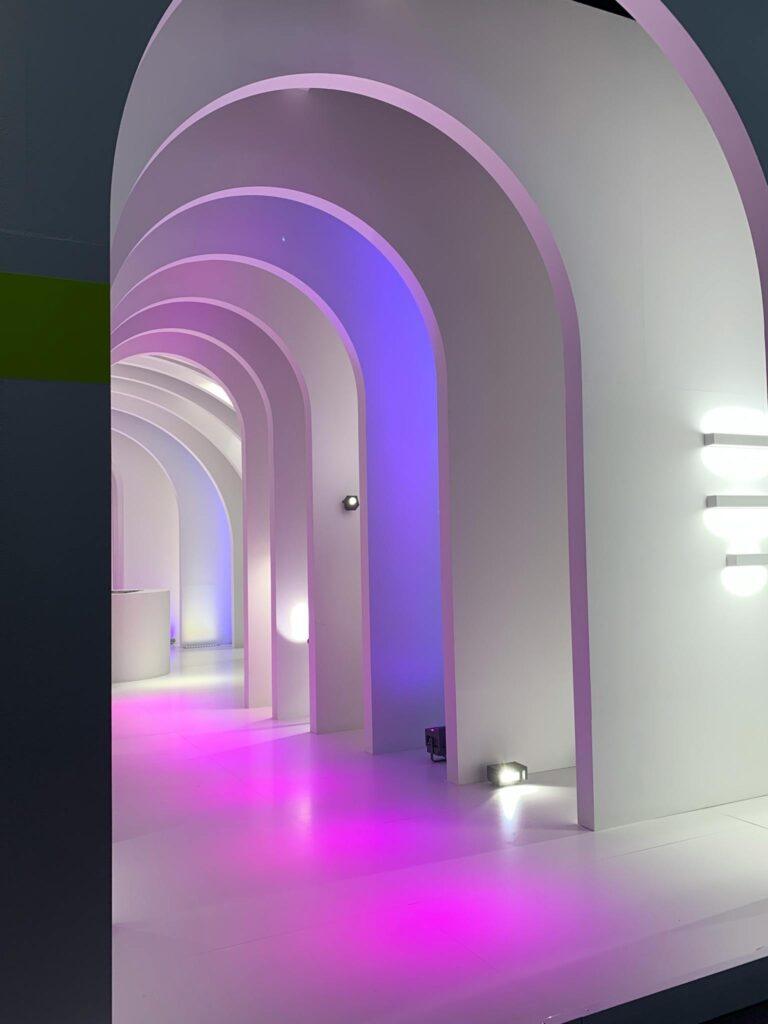 A stunning view of a modern corridor with illuminated arches and a vibrant purple glow, creating a unique interior space.