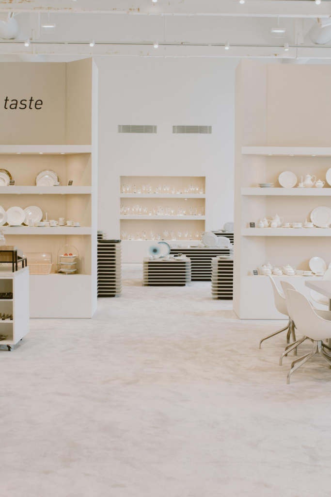 Elegant minimalistic interior showcasing white ceramics on shelves with a clean, spacious layout.