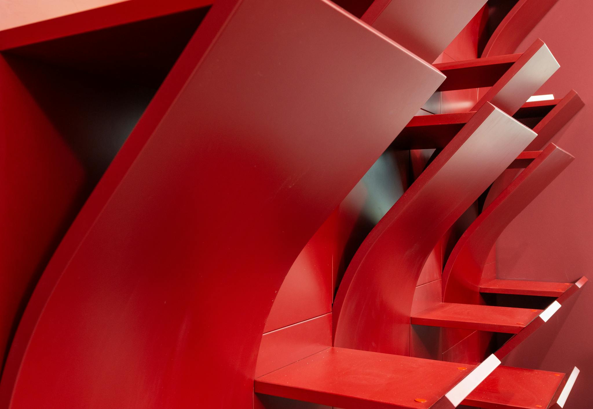 Interior of modern light office with empty red shelves with geometric design near wall